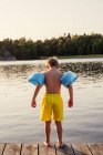 Vista posteriore del ragazzo che indossa ali d'acqua in piedi sul molo — Foto stock