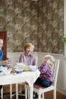 Mother with two children eating breakfast — Stock Photo