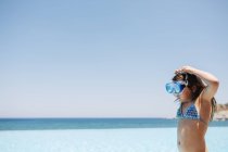 Вид сбоку девушки в купальниках на фоне голубого неба — стоковое фото