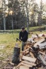Homem adulto médio cortar logs, foco seletivo — Fotografia de Stock