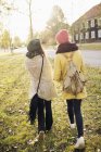 Visão traseira de duas mulheres jovens caminhando, foco seletivo — Fotografia de Stock