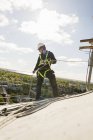 Bauarbeiter in Schutzkleidung seilt sich vom Dach ab — Stockfoto