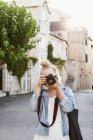 Молодая женщина фотографирует, фокусируется на переднем плане — стоковое фото