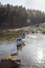 Мальчики катаются на каноэ по реке летом, избирательный фокус — стоковое фото