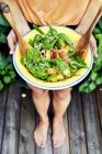 Jovem mulher segurando prato com salada — Fotografia de Stock