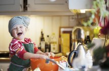 Щаслива дівчина випікає на кухні, вибірковий фокус — стокове фото