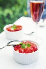 Deserto di fragole in ciotole con bicchiere di vino in tavola, focus selettivo — Foto stock