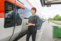 Жінка в навушниках на залізничній платформі — стокове фото
