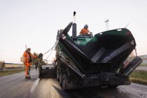 Três trabalhadores manuais reparando estrada, foco seletivo — Fotografia de Stock