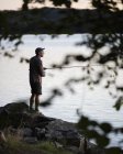 Mid adult man fishing, differential focus — Stock Photo