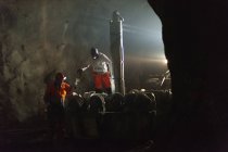 Mineros en ropa de trabajo protectora trabajando bajo tierra - foto de stock