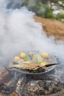 Food cooking on campfire, focus on foreground — Stock Photo