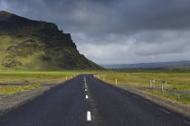 Camino rural bajo nubes de tormenta en Islandia - foto de stock