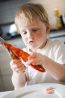 Niño comiendo cangrejos de río, enfoque diferencial - foto de stock