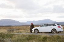 Две женщины с машиной на обочине дороги в Исландии — стоковое фото