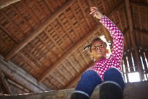 Low angle view of girl sitting in barn — Stock Photo