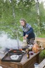 Donna che cucina sul pozzo di fuoco nella foresta, concentrarsi sul primo piano — Foto stock