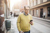 Человек с помощью смартфона на улице, сосредоточиться на переднем плане — стоковое фото