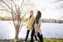 Zwei junge Frauen gehen am Kanal entlang, konzentrieren sich auf den Vordergrund — Stockfoto