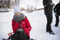 Jovem mulher sentada no trenó no inverno — Fotografia de Stock