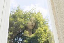 Mädchen schaut aus dem Fenster, selektiver Fokus — Stockfoto