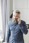 Мужчина в рубашке с пятнами разговаривает по телефону — стоковое фото