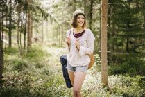 Молода жінка мандрівного в лісі, зосередити увагу на передньому плані — стокове фото