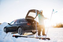 Человек на машине с лыжной экипировкой, избирательный фокус — стоковое фото