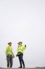 Low angle view of woman talking to construction worker — Stock Photo