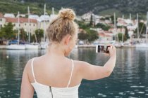 Junge Frau macht Selfie, konzentriert sich auf den Vordergrund — Stockfoto