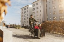 Homem de bicicleta com filhos, foco seletivo — Fotografia de Stock