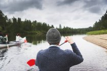Homme ramant sur la rivière dans le nord de la Suède — Photo de stock