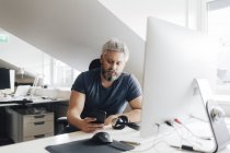Man at office desk using smart phone, selective focus — Stock Photo