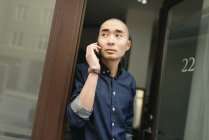 Young man talking on mobile phone, focus on foreground — Stock Photo