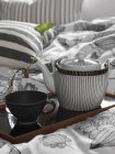 Крупным планом чайник и чашка на подносе в спальне — стоковое фото
