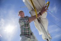 Low angle view of mature man preparing for sailing — Stock Photo