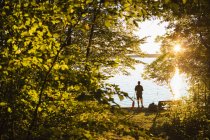 Silhouette dell'uomo in piedi con remo al tramonto — Foto stock