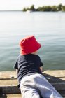 Vue arrière du garçon allongé sur la jetée, mise au point sélective — Photo de stock