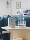 Alarm clock and bottle in bedroom, selective focus — Stock Photo