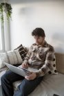 Mitte erwachsener Mann mit Laptop im Wohnzimmer — Stockfoto