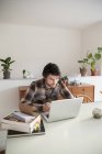 Hombre adulto medio usando el ordenador portátil en la oficina en casa - foto de stock
