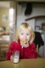 Girl eating breakfast, focus on foreground — Stock Photo