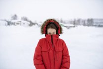 Portrait of young woman wearing red parka in winter — Stock Photo