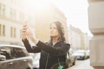 Frau macht Selfie auf der Straße, Fokus auf Vordergrund — Stockfoto