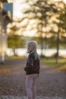 Porträt eines Mädchens, das im Flusspark spaziert und über die Schulter schaut — Stockfoto