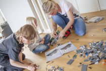 Mutter spielt mit Kindern im Wohnzimmer — Stockfoto