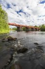 Red bridge over river, Vasterbotten County — Stock Photo
