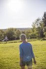 Visão traseira da mulher loira no prado — Fotografia de Stock