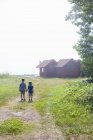 Visão traseira de dois meninos de mãos dadas ao ar livre — Fotografia de Stock