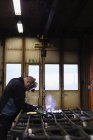 Mature man welding construction frame — Stock Photo